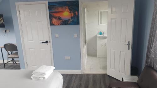 a bathroom with a white bed and a sink at Harington Homes in Palmers Green