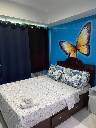 een slaapkamer met een bed met een vlinder aan de muur bij Azure Urban Suite Room in Manilla