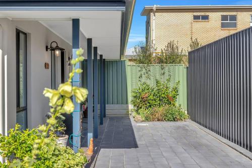 a walkway leading to a house with a fence at 'Waurra' A Cosy Moana Beach Getaway in Adelaide
