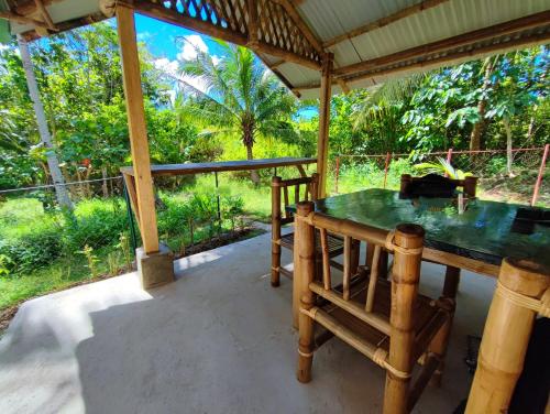 a porch with a table and chairs and trees at Rose Apartments in Anda