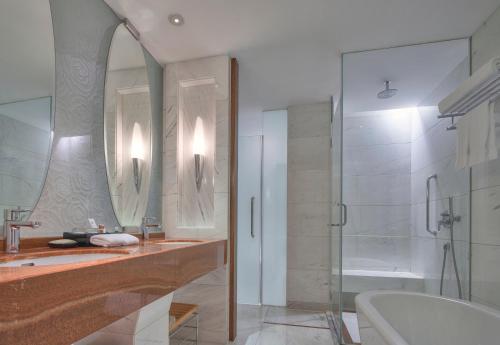a bathroom with a shower and a sink and a tub at Sheraton Zhoushan Hotel in Zhoushan