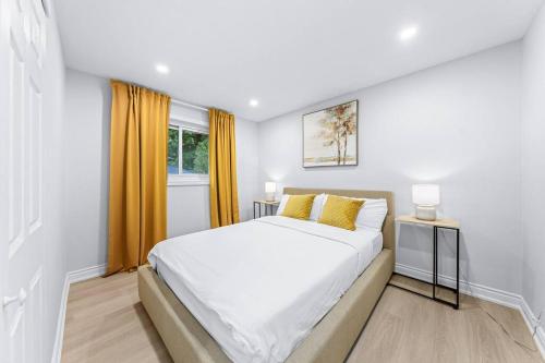 biała sypialnia z łóżkiem i oknem w obiekcie Charming 3-Bed House with HotTub w mieście Barrie