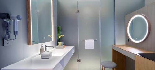 a bathroom with a white sink and a mirror at Pagoda Hotel Hangzhou Binjiang in Hangzhou