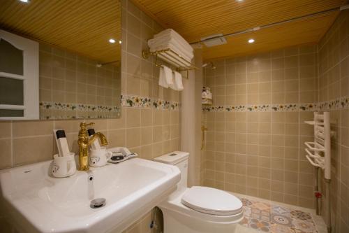 y baño con lavabo blanco y aseo. en Rose Garden Lijiang, en Lijiang