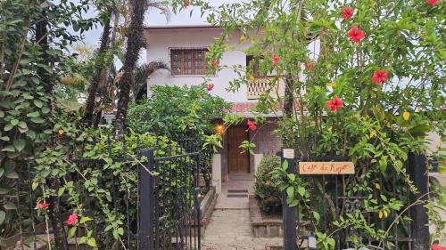 uma entrada para o jardim de uma casa com flores vermelhas em Casa de Rojo 3 Bedroom house with private Pool and all amenities em Bocas del Toro