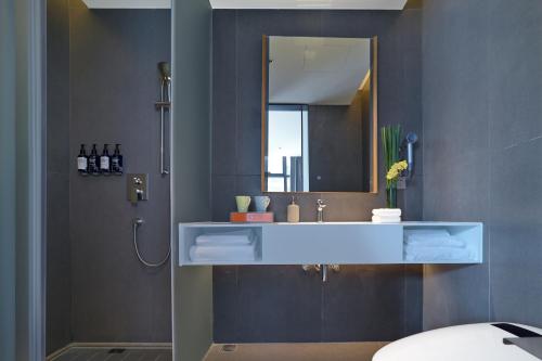 a bathroom with a sink and a mirror at Pagoda Hotel Hangzhou Binjiang in Hangzhou