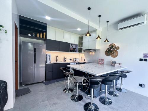 a kitchen with a counter island and a refrigerator at A's Hideaway Pampanga in Guagua