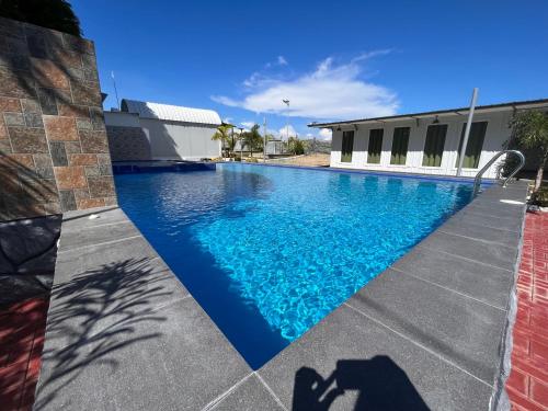 einem Pool mit blauem Wasser vor einem Gebäude in der Unterkunft Camp Palo Bandera in Calatagan