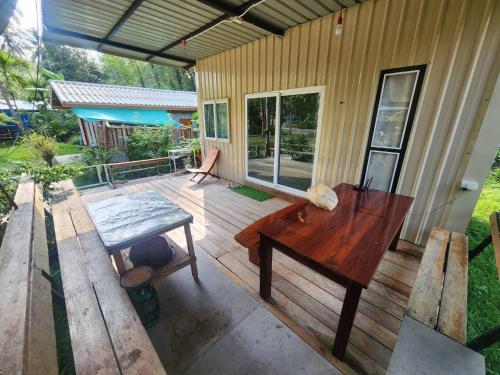 a patio with a wooden table and a desk at Lung peiyk homestay in Ban Bang Bao