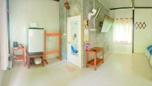 a room with a refrigerator and a table in it at Lung peiyk homestay in Ban Bang Bao