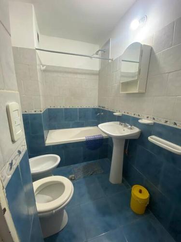 ein blau-weißes Bad mit einem WC und einem Waschbecken in der Unterkunft Alquiler departamento amoblado in Río Cuarto