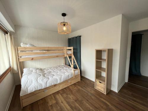 - une chambre avec des lits superposés et un lustre dans l'établissement Superbe appartement rénové aux Gets, proche centre et pistes, balcon, casier à skis - FR-1-623-155, aux Gets