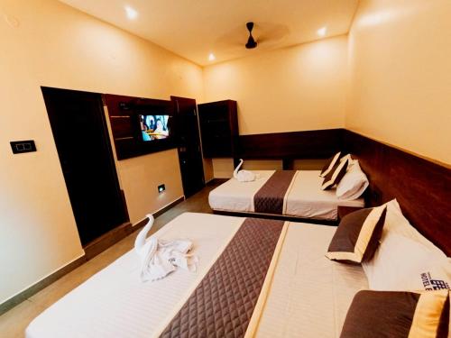 ラーメーシュワラムにあるHOTEL ELITEのベッド2台、薄型テレビが備わる客室です。