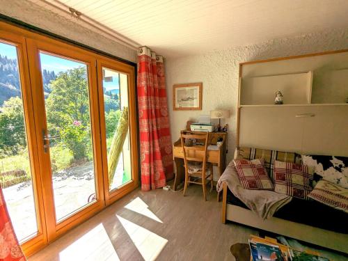 une chambre avec un lit, une table et une fenêtre dans l'établissement Appartement 6 pers, proche pistes, terrasse et parking inclus à La Clusaz - FR-1-459-217, à La Clusaz