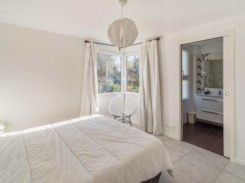 a white bedroom with a bed and a window at Villa lumineuse 4 étoiles, 50m de la plage, jardin clos, tranquillité à Trégastel - FR-1-368-399 in Trégastel