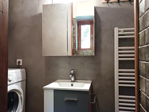 une salle de bain avec un lavabo et une machine à laver dans l'établissement Charmant 2 pièces rénové, exposé sud, à 50m des pistes, WiFi, TV, parking, casier à skis - FR-1-411-901, à Bourg-Saint-Maurice