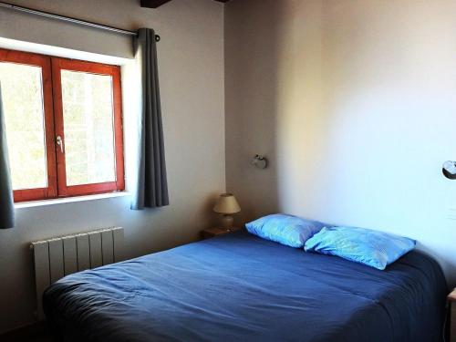 une chambre avec un lit bleu et une fenêtre dans l'établissement Charmant 2 pièces rénové, exposé sud, à 50m des pistes, WiFi, TV, parking, casier à skis - FR-1-411-901, à Bourg-Saint-Maurice