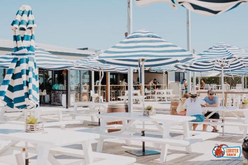 a group of white tables and blue and white umbrellas at Cervantes Lodge in Cervantes