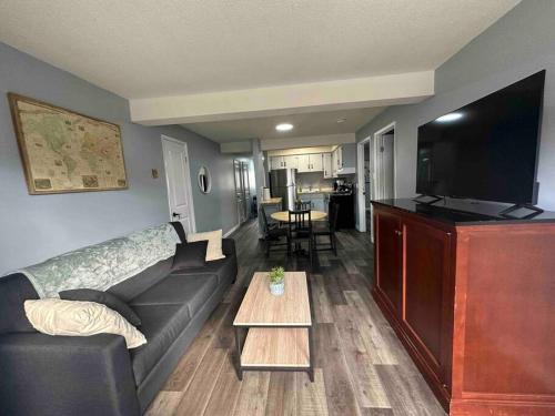 a living room with a couch and a flat screen tv at Freshly Renovated 2 bedroom unit in Cornwall