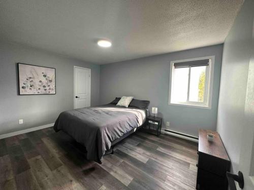 a bedroom with a bed and a window at Freshly Renovated 2 bedroom unit in Cornwall