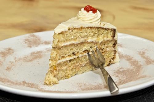 a piece of cake on a plate with a fork at Bahnhof Hotel Aus in Aus