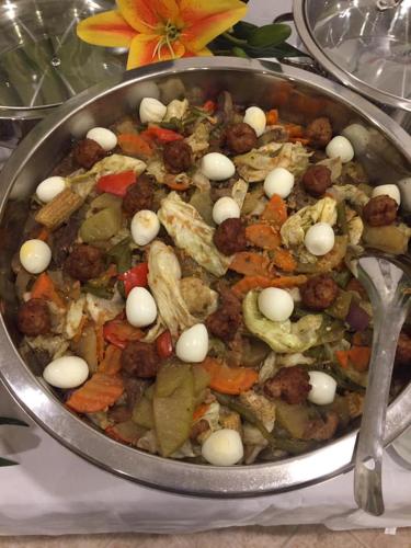 a pan full of food with meat and vegetables at Villa Italia Hotel in Sorsogon