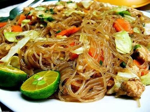 a white plate of food with noodles and vegetables at Villa Italia Hotel in Sorsogon