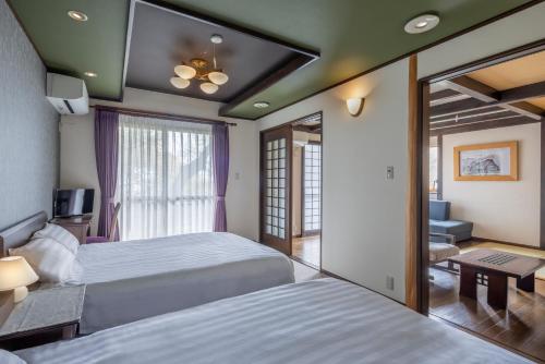 a hotel room with two beds and a mirror at ちどり庵 in Shio