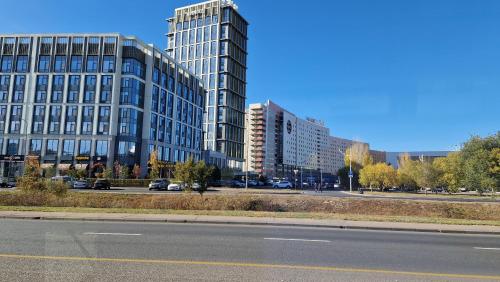 an empty street with tall buildings in a city at Стильная квартира в ЖК бизнес класса AVENUE 5 in Astana