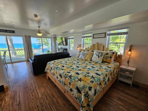 um quarto com uma cama, um sofá e janelas em SeaSide Lake-Front Cottage em Madison