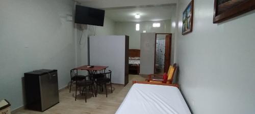 um quarto com uma cama, uma mesa e cadeiras em Mini Departamento Iquitos 1243 em Iquitos