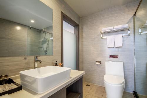 uma casa de banho com um lavatório branco e um WC. em Suberun Hotel - Jinyang Street em Taiyuan