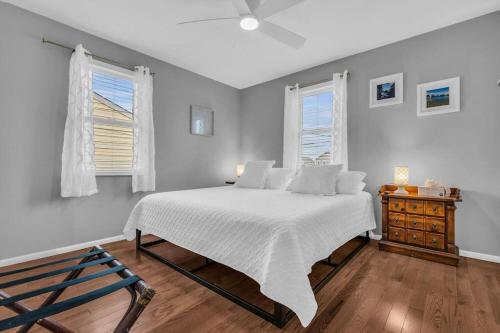 1 dormitorio con 1 cama blanca y 2 ventanas en Barnegat Bay Cottage: A 'MyShoreCottage' Property, en Seaside Park