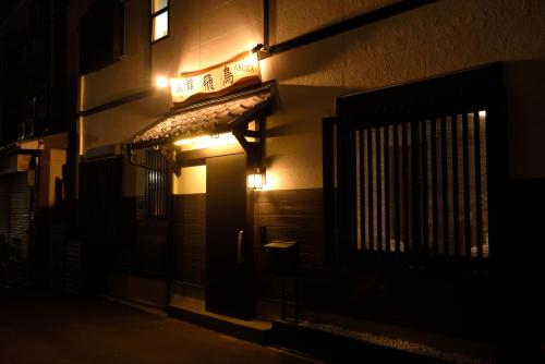 a building with a sign on the side of it at night at NEW-130m2 with 5toilets & 4 showers-Namba and USJ nearby in Osaka