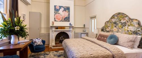 a living room with a bed and a fireplace at Summerlands - Country Luxe in Alexandra