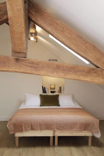 une chambre avec un lit dans un grenier dans l'établissement Maison Le Moulin Vert by La Boîte En Plus, à Senlis