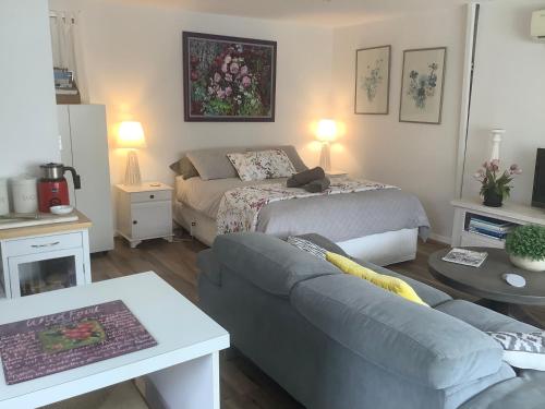 uma sala de estar com uma cama e um sofá em Petite Provence Cottage em Blairgowrie