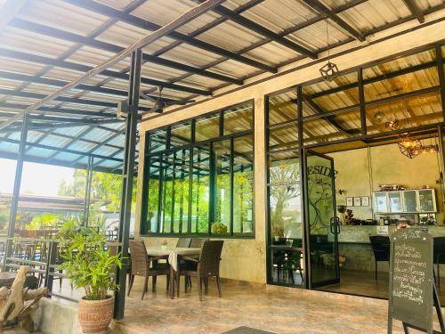 uma sala de jantar com uma mesa e algumas janelas em Treeside Guest House Resort em Ban Thung Chao