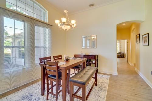 a dining room with a table and chairs and a chandelier at Ranch-Style Florida Retreat with Pool and Lanai in Merritt Island