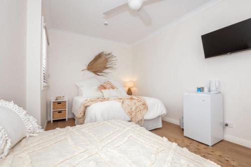 a bedroom with two beds and a flat screen tv at Cervantes Lodge in Cervantes