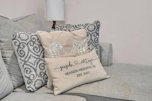 a couch with a pillow on it with a wedding anniversary pillow at Seaside Cottage: A 'MyShoreCottage' Property in Seaside Heights