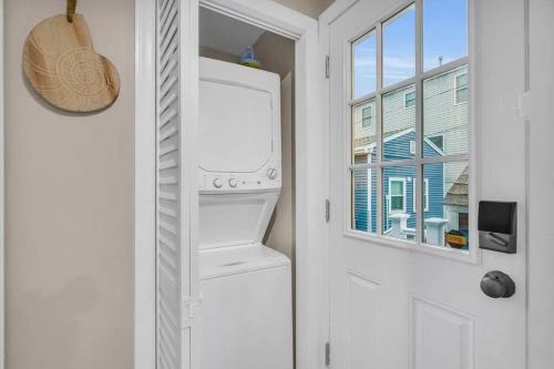 einen weißen Kühlschrank in einer Küche neben einer Tür in der Unterkunft Seaside Cottage: A 'MyShoreCottage' Property in Seaside Heights
