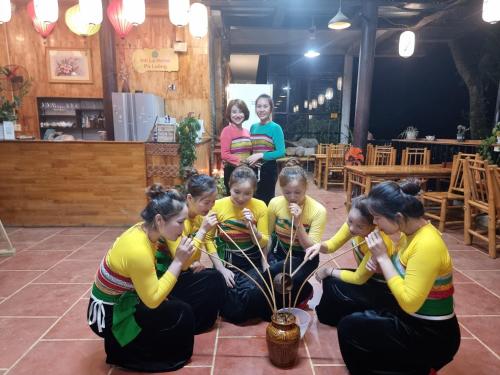 a group of women playing with a plant at Inh La Home Pu Luong in Pu Luong