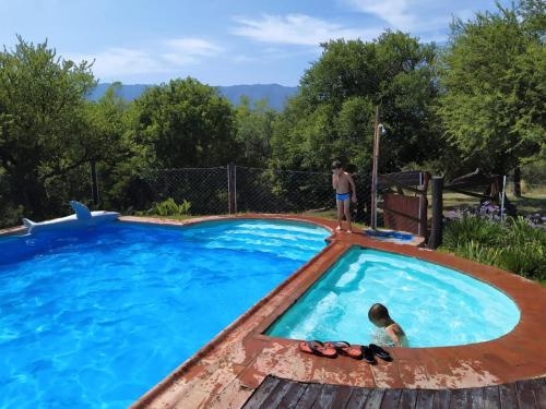 a swimming pool with two people standing in the water at Viejo Molino in Nono