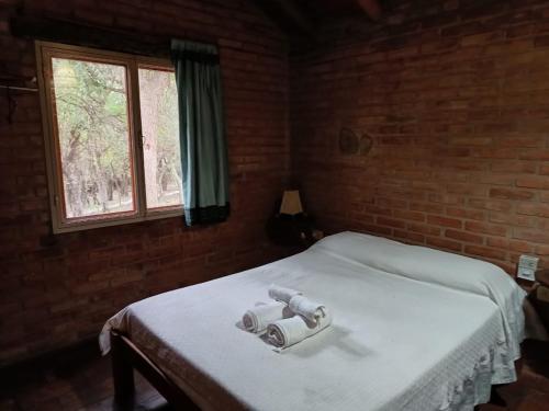a bedroom with a white bed with a window at Viejo Molino in Nono