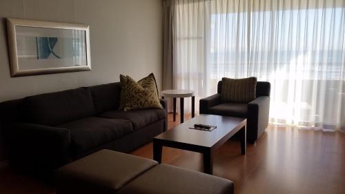 a living room with a couch and a chair at Lagoon Beach Hotel & Spa in Cape Town