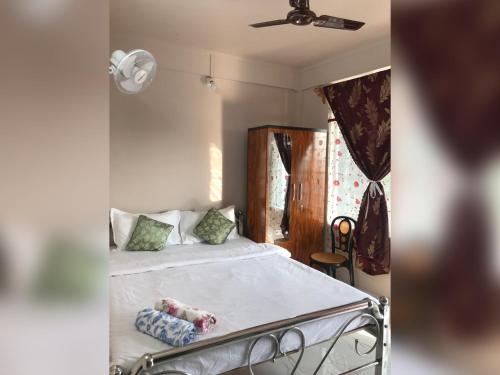 - une chambre avec un lit et un ventilateur de plafond dans l'établissement Living Roots Lodge, à Cherrapunji