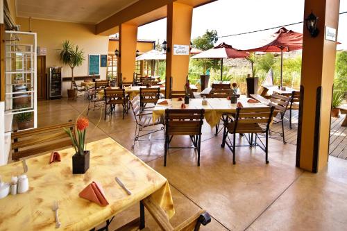 a restaurant with tables and chairs and umbrellas at Bahnhof Hotel Aus in Aus