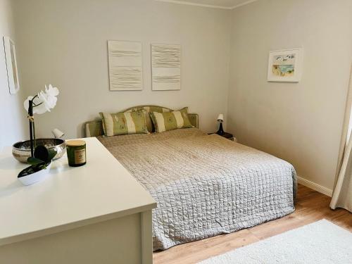 1 dormitorio con 1 cama y 1 mesa con flores en Traumwohnung mit Stadthafen-Panorama! Zwei Schlafzimmer, Parkplatz, en Rostock