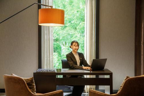 a man sitting at a desk with a laptop at Hotel GrandBach Tokyo Ginza in Tokyo